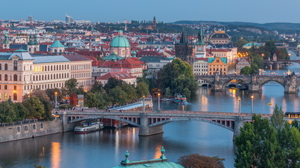 Wall Mural - Aerial evening view of the Vltava River and illuminated bridges day to night timelapse, Prague