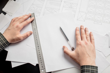 Wall Mural - ux website designer drawing wireframe sketch of prototype, framework, layout future project. creativ