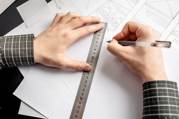 Wall Mural - ux website designer drawing wireframe sketch of prototype, framework, layout future project. creativ