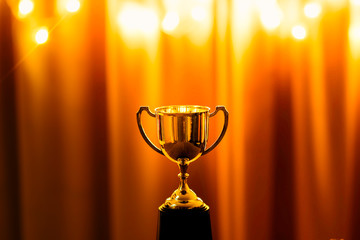 Wall Mural - gold trophy competition in the dark on the abstract blurred light background with copy space, specta