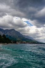 Stormy Weather In Brela, A Famous Tourist Resort At Adriatic Sea With Dramatic Dark Clouds Rolling Over Biokovo Mountain.