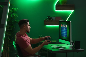 Wall Mural - Young man playing computer game in club