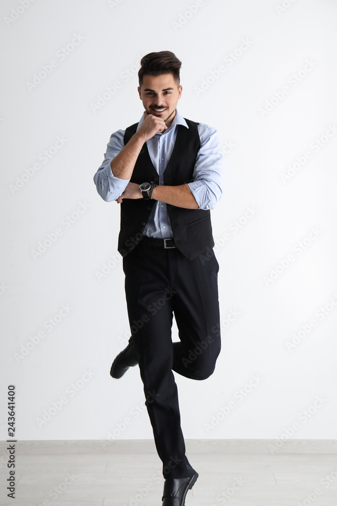 Jumping handsome man against white wall
