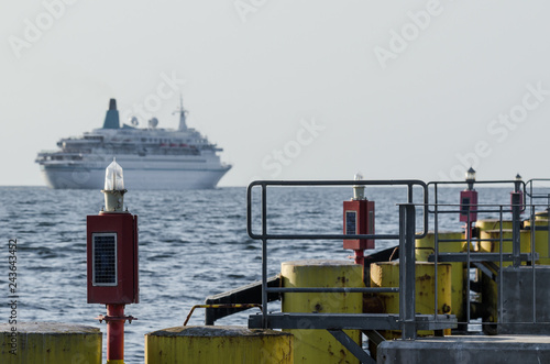 Fotografie, Obraz NAVIGATION LIGHT - Infrastructure of sea port in Kolobrzeg and a cruise ship in