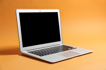 Modern laptop on color background