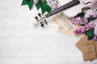 A bouquet of lilacs with violin, letter and music sheet on a white wooden table. Top wiev with space for your text