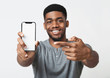 © Prostock-studio - Happy black man holding latest slim smartphone