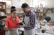 © WavebreakMediaMicro - Male and female potter discussing over tablet pc