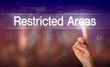 A hand selecting a Restricted Areas business concept on a clear screen with a colorful blurred background.