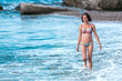 © zhukovvvlad - A woman in a bathing suit comes out of the sea.