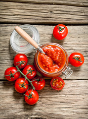 Canvas Print - Tomato sauce in a glass jar with fresh tomatoes.