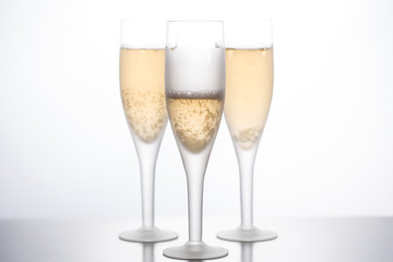 Glasses with champagne empty and filled on a white background.