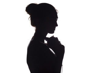 Silhouette of a girl with with headphones around neck, a young woman listening to music on a white isolated background, concept of hobby and relaxation