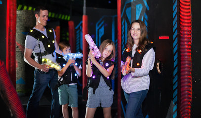 Wall Mural - Woman with daughter playing laser tag