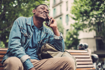 Wall Mural - Young african-american with mobile phone outdoors