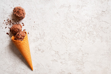 Background with balls of chocolate ice cream in the waffle cone