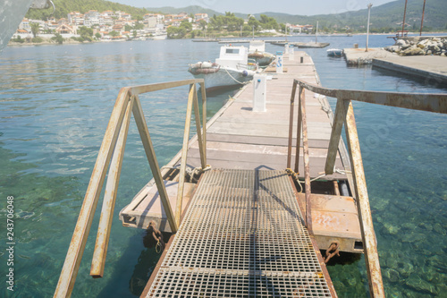 Foto A metal bridge leading to the dock with boats