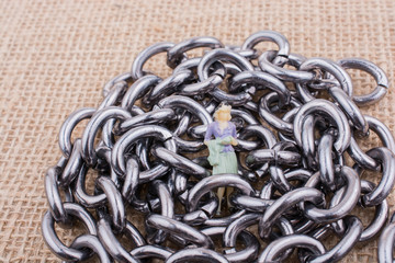 Wall Mural - Woman figurine on steel chains on a textured surface