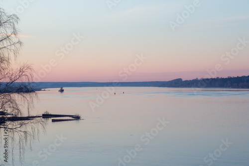 Foto Peaceful spring landscape at sunset on the river with ship and forest in the background