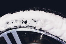 Car Care Or Car Detailing Process. Using Black Sponge To Washing The Tire. Blacker Rubber.