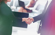 © ASDF - handshake business partners at the negotiating table.