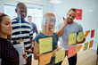 © Flamingo Images - Designers brainstorming with sticky notes during an office meeti