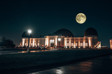 Wall Mural - Los Angeles, CA / USA - September 18 2018: Griffith Observatory at night with thousands of stars, full moon and a milky way in the skies.