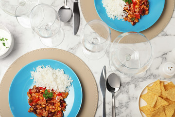 Tasty chili con carne served with rice on marble table. Dinner in restaurant