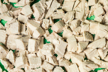 Wall Mural - Diced boiled chicken meat on a green board