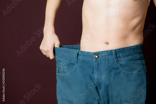 Fotografia person show weight loss by wear large size trousers b