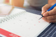 © surasaki - Hands of businesswoman is planning and managing work on the calendar.