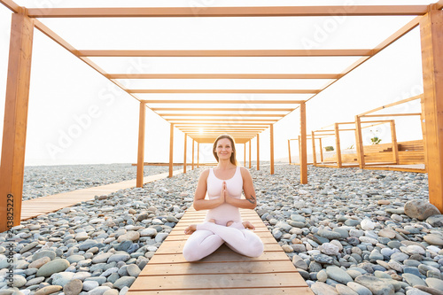 Fotografia Graceful and flexible sporty young woman fitness or yoga instructor meditating a
