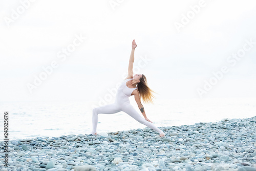 Fotografie, Obraz Flexible and athletic slim young female athlete blonde in a tight white suit mak