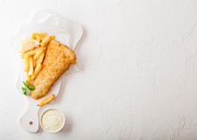 Traditional British Fish And Chips With Tartar Sauce On Chopping Board On White Stone Table Background. Space For Text