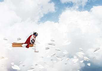 Girl power concept with cute kid guardian against cloudscape bac