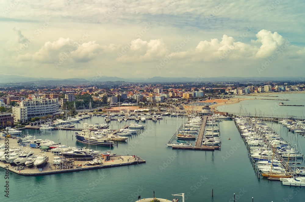 Aerial view of boats, yachts, floating ships. Landscape with boats in marina bay, sea, buildings in city. Top view of harbor with sailboats.