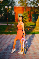 Wall Mural - Latin woman in pink dress with flowers and pink bicycle.