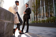 © Monkey Business - Two young adult colleagues standing on the street talking, low angle