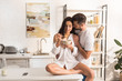 © LIGHTFIELD STUDIOS - man embracing beautiful woman during breakfast in kitchen