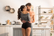 © LIGHTFIELD STUDIOS - selective focus of young seductive couple passionately hugging in kitchen