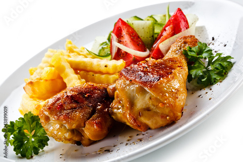 Fototapeta na szkło Drumsticks with french fries and vegetable on white background