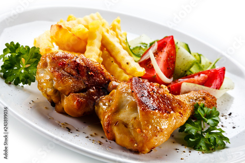 Fototapeta na szkło Drumsticks with french fries and vegetable on white background