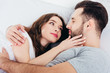 © LIGHTFIELD STUDIOS - young loving woman gentle looking in eyes of man in bed