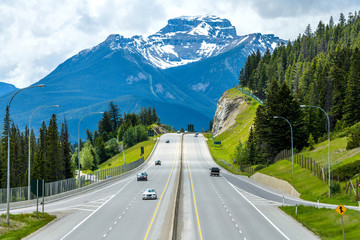 Trans-Canada Highway at Banff - A cloudy Spring day view of Trans-Canada Highway at exit to Banff Townsite, with massive Mt. Bourgeau standing high in background, Banff National Park, AB, Canada.