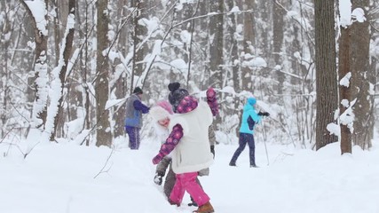 Wall Mural - Two little girls running and playing snowballs in winter forest.