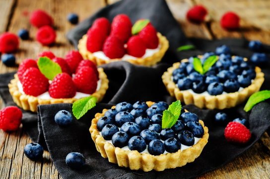 Raspberry and blueberry tartlets with fresh berries and mint leaves