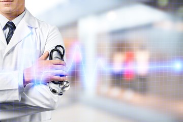 Wall Mural - Male doctor with stethoscope on blurred hospital background