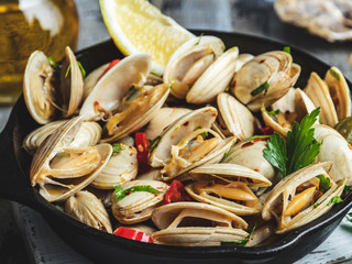 Wall Mural - Cooked seafood clams in the iron pan portion with lemon and seasoning