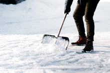 Close Up Of Adult Cleaning Snow From Sidewalk And Using Snow Shovel After Heavy Snowstorm
