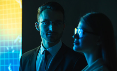 Wall Mural - The business couple in glasses standing near the screen